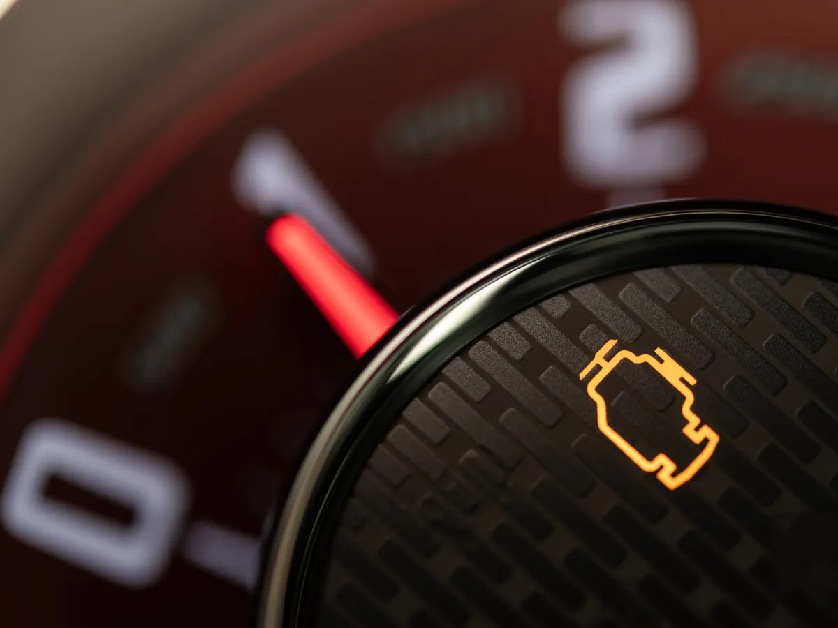 Kontrolka check engine na czerwonym obrotomierzu