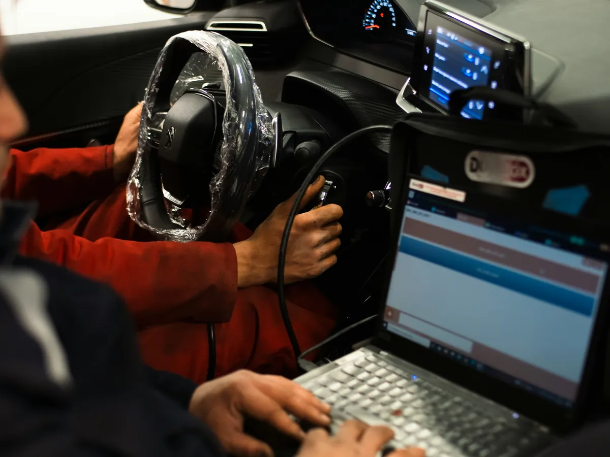 Laptop diagnostyczny podłączony do auta w kabinie